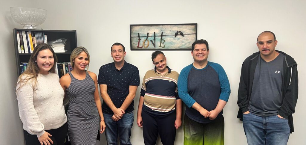 A group of people standing in front of a wall.