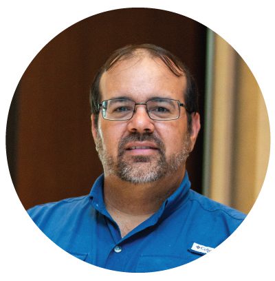 Man with glasses wearing a blue shirt.