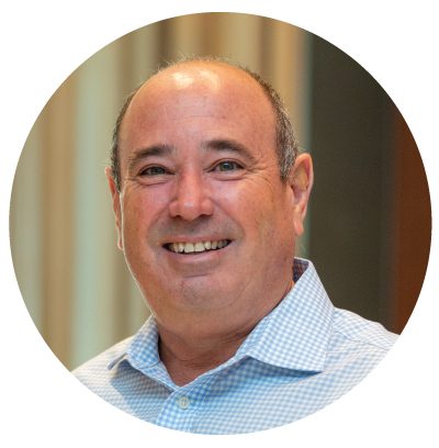 Smiling man in a blue checkered shirt.