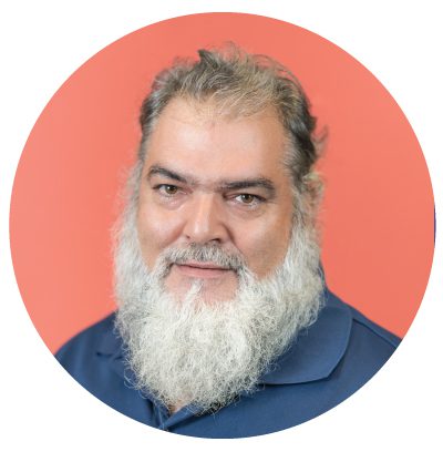 Man with beard against a red background.