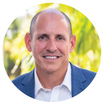 Smiling man in suit, outdoor background.