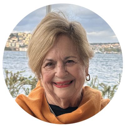 Smiling woman by a waterfront background.